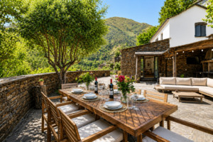 Luxury stone terrace with outdoor dining, lounge seating and BBQ overlooking the mountains at Peregrinus Rio de Frades in Arouca, Portugal.